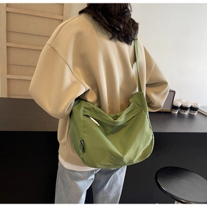 Detail view of a green nylon dumpling bag showing large capacity and zipper pocket