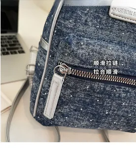 Detail of smooth silver zipper and polka dot denim texture on a stylish mini backpack