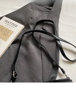 Detail of adjustable black faux leather shoulder strap with silver metal lobster clasps