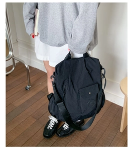 Versatile black nylon multi-way travel bag shown in hand and shoulder carry style