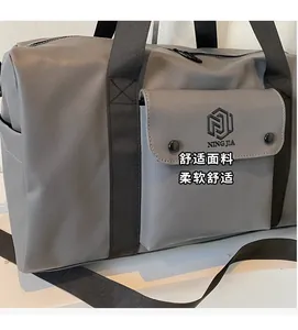 Detail view of the gray textured gym bag with front button pockets and brand logo print