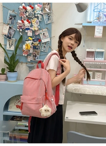 Détail d'un sac à dos en toile à carreaux rouges et blancs avec bretelles et étoile