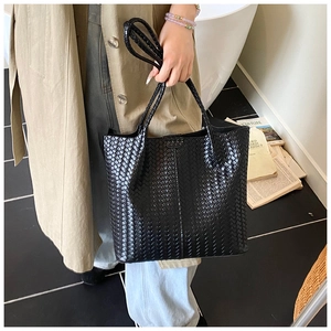 Close-up of the black woven leather tote bag with a high-quality textured finish