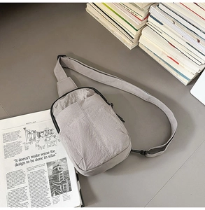 Primer plano de la bandolera de nailon gris claro con correa ajustable deportiva