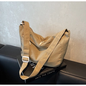 Detail of khaki pleated nylon crossbody bag with wide strap and white adjustment buckle