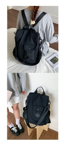 Detail view of black waterproof nylon backpack featuring adjustable straps and front pocket