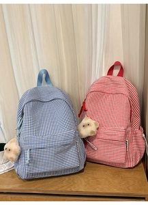 Détail de sacs à dos à carreaux bleu et rouge avec de mignons porte-clés étoile en peluche
