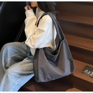 Gros plan sur un grand sac cabas au motif à petits carreaux sombres et toile épaisse