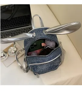 Detail view of denim backpack interior showing storage space for phone and umbrella