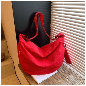Detail of red crescent nylon bag with adjustable strap and mini storage pouch