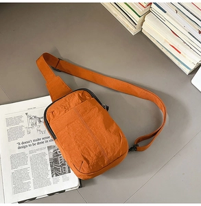 Detalle macro de la tela de nailon arrugado naranja en este bolso bandolera casual