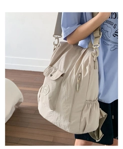 Detail view of large capacity beige nylon backpack with adjustable shoulder straps