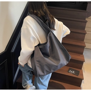 Détail d'un grand sac cabas à carreaux montrant la texture fine du tissu tissé
