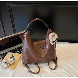 Dettaglio della borsa tote in pelle marrone scuro con ciondolo decorativo a forma di alpaca