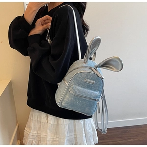 Detail view of light blue sequin mini backpack with cute silver rabbit ear decorations
