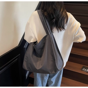 Détail d'un grand sac cabas à carreaux noir et blanc avec une bandoulière large