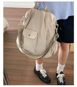 Detail of beige multifunctional nylon backpack showing large capacity and side pockets