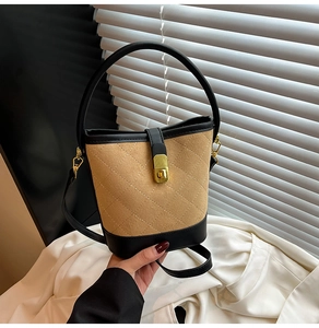 Détail du sac seau en daim matelassé avec coutures contrastées et fermoir doré chic