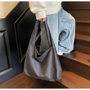 Détail du grand sac cabas à carreaux montrant sa capacité et sa texture en toile décontractée