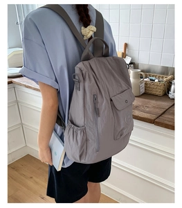 Detailed view of grey-blue waterproof nylon travel backpack shown in home setting