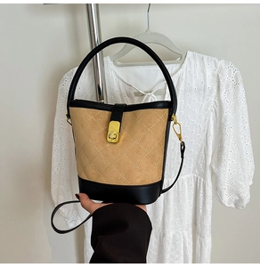 Détail du sac seau matelassé kaki avec boucle dorée et finitions en cuir noir élégant