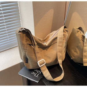 Detail of khaki pleated crossbody bag with adjustable wide strap and nylon texture