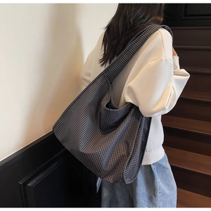 Gros plan sur le sac fourre-tout en toile à carreaux bleu marine avec large bandoulière