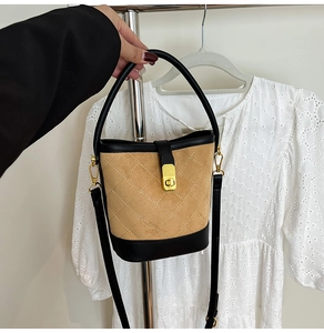 Détails de sac seau matelassé avec fermoir doré rotatif et finitions en cuir noir