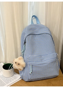 Détail du sac à dos à carreaux bleus avec pendentif étoile en peluche et poche avant