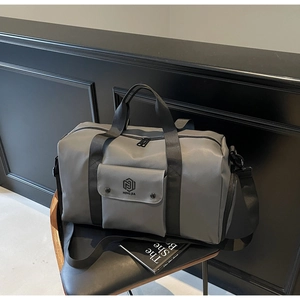 Close-up of gray gym bag with waterproof fabric, front magnetic pocket and side shoe compartment