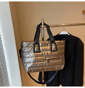 Détails d'un sac cabas matelassé or champagne avec sangles noires et fermeture éclair