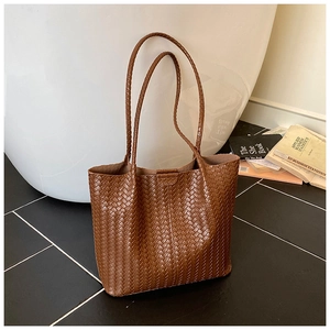 Detailed close-up of dark brown woven tote bag featuring high-quality leather texture