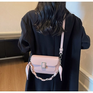 Pink mini crossbody bag with crocodile texture and silk scarf handle shown on model