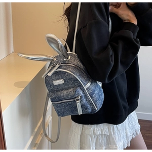 Detail of mini denim backpack with glitter texture and silver 3D rabbit ears