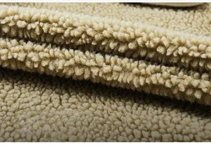 Dettaglio del tessuto pile beige con texture morbida e materiale termico spesso