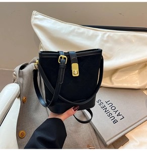 Détail du sac seau matelassé noir avec fermoir doré tournant et texture mate élégante