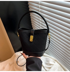 Détail du sac seau noir matelassé avec textures mixtes et boucle en métal doré élégante