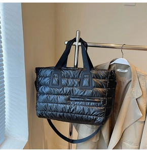 Détail d'un cabas en nylon noir matelassé avec poche zippée et texture rembourrée douce