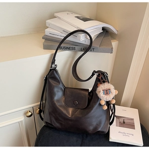 Dettaglio borsa tote in pelle marrone scuro con ciondolo a pecora e tracolla regolabile