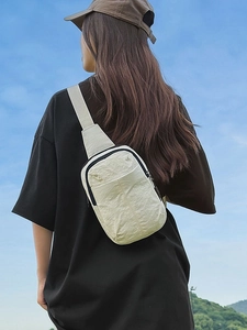 Bolso bandolera minimalista blanco crema con tela texturizada usado al aire libre