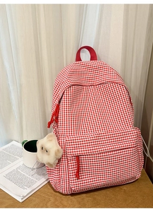 Détail du sac à dos vichy rouge et blanc avec fermetures éclair en corde et breloque