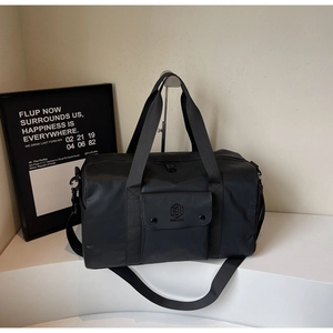 Close-up of black gym bag with adjustable shoulder strap and dual top handles on display