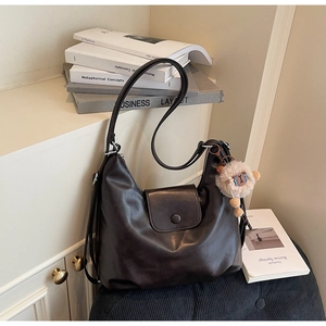 Dettaglio della borsa hobo in pelle caffè scuro con un grazioso ciondolo a forma di agnello
