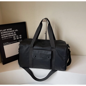 Close-up of black waterproof fitness bag featuring snap front pocket and logo detail