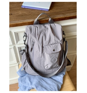 Detail of mauve nylon multipurpose backpack with vertical zipper and round logo patch