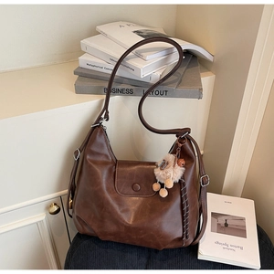 Dettaglio della borsa tote vintage marrone scuro con patta magnetica e ciondolo in peluche