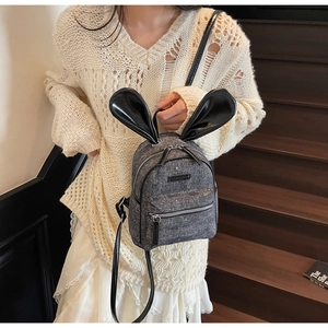 Mini gray glitter backpack with large black leather rabbit ears shown on a model