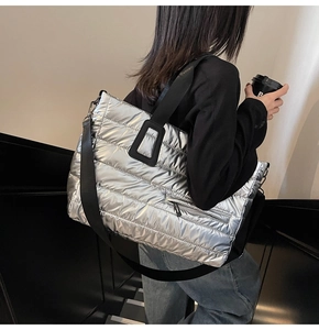 Détail d'un sac cabas argenté matelassé avec sangles noires et poche zippée latérale