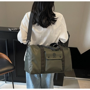 Detail of waterproof dark green fitness bag with adjustable shoulder strap and logo