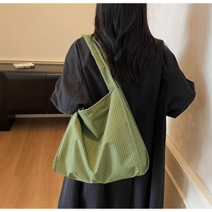 Détail du sac cabas à carreaux verts montrant son design spacieux et sa texture tissée